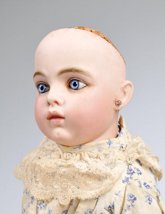 Bru Jne 5 Bisque Head Doll, France, c. 1885, classic Bru bebe incised Bru Jne 5, deep blue paperweight eyes, clearly modeled closed mouth with tongue tip, the somewhat quizzical expression apparent on this model, no wig, perhaps she is worried about having lost it, shoulderplate with molded bosom, bisque lower arms, kid body, original cotton dress and shoes marked Bru Jne 5, ht. 15 in. Provenance: Doll has been in the family of the original child-owner. Estimate: $15,000-18,000. Skinner image. Provenance:  Doll has been in the family of the original child-owner.  Family information will be provided with the doll.