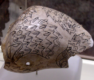 An example of artwork engraved on a whelk shell cup from Spiro Mounds, Oklahoma. The design includes imagery of raptor heads. Photo by Heironymous Rowe at en.wikipedia, licensed under the Creative Commons Attribution-Share Alike 3.0 Unported license.