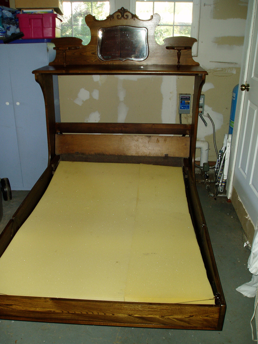 The frame of this folding bed made by National Wire Mattress Co. folded in half to fit into the cabinet.