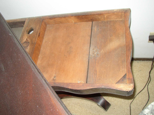 The fold-over top of the mid-century game table slides aside to reveal the storage space below.