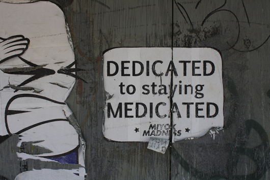 Miyok’s disgruntled pill salutes faces off with McCarren Park in Williamsburg.   ‘Dedicated to Staying Medicated’ by Miyok. Photo by Kelsey Savage. 