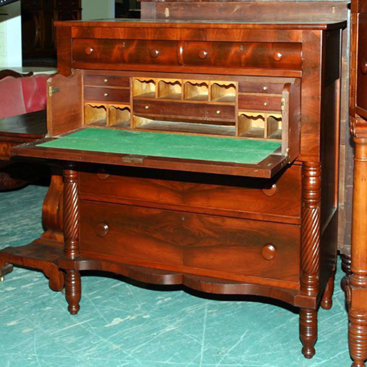 In this case the secretarial space was placed in the top drawer of chest creating the butler’s desk.