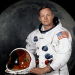 Portrait of Astronaut Neil A. Armstrong (American, 1930-2012), commander of the Apollo 11 Lunar Landing Mission in his space suit, with his helmet on the table in front of him. Behind him is a photograph of the lunar surface. NASA Photo No. S69-31741, taken July 1, 1969.