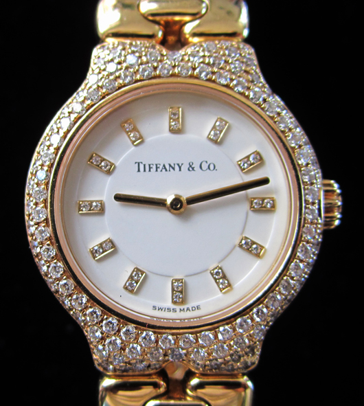 Ladies Tiffany and Co. 18K yellow gold watch with 134 diamonds on bezel, diamond markers on dial. Original Tiffany box. Est. $5,500-$7,000. WatchAuctionHQ image.