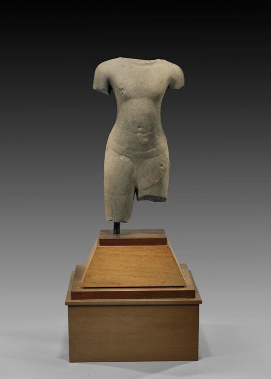 Cambodian (Khmer) sandstone torso of male subject, circa 12th/13th century, approx. 30 inches high, mounted on wood pedestal stand. Est. $12,000-$15,000. I.M. Chait image.
