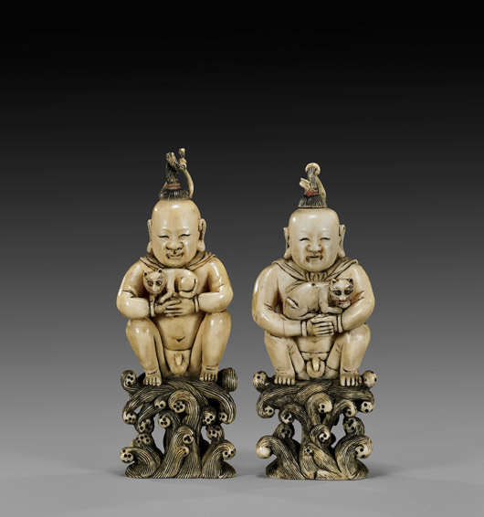 Pair of antique carved-ivory snuff bottles replicating nude boys, each holding a cat, with stoppers formed as ‘hair’ topknots, each 4 7/8 inches high. Est. $1,200-$1,500. I.M. Chait image.