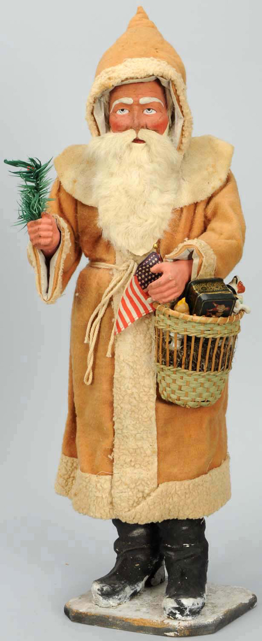 22-inch Santa candy container, composition hands and face, fur beard, with basket of toys, fir sprig and American Flag, $5,100. Morphy Auctions image.