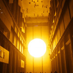 Olafur Eliasson's better-known installations include 'The Weather Project,' 2003, at Tate Modern in London. Eliasson used humidifiers to create a fine mist in the air via a mixture of sugar and water, and installed a semicircular disc composed of hundreds of monochromatic lamps that radiated yellow light. Photo by Thomas Pintaric, licensed under the Creative Commons Attribution-Share Alike 3.0 Unported license.