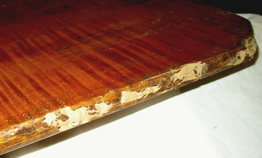 The damage to this 18th century New England tiger maple tilt-top was done by dry wood termites after it was moved south and placed in unprotected storage.