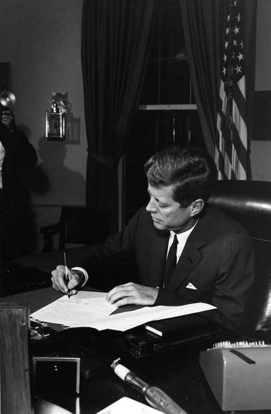 President Kennedy signs the Proclamation for Interdiction of Delivery of Offensive Weapons to Cuba at the Oval Office, Oct. 23, 1962.