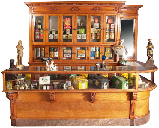 Tobacco and cigar store back bar and counter featuring a marble base with curved glass corner. Price realized: $55,000. Showtime Auction Services image.
