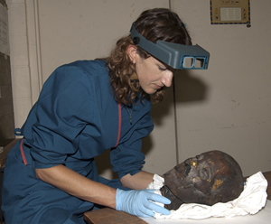 Molly Gleeson, the Penn Museum's project conservator, examines a gilded, mummified human head dating to the Roman period (after 30 CE) to understand its condition and determine if any conservation treatment is necessary. Photo: Penn Museum.