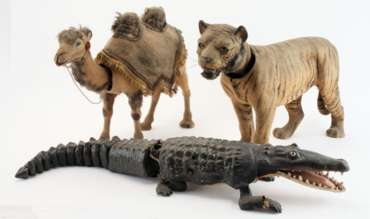 Mechanical animals made in first quarter of 20th century: nodding Bactrian Camel in circus garb, nodding glass-eyed Tiger, and Alligator made by Decamps. Noel Barrett Auctions image.