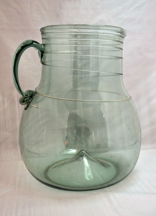 South Jersey free-blown water pitcher, light green glass with applied spiral threading, applied solid handle with crimped end, broken pontil, 10 7/8 inches tall x 9 inches diameter. Estimate: $1,000-$6,000. Kennedy’s Auction Service.