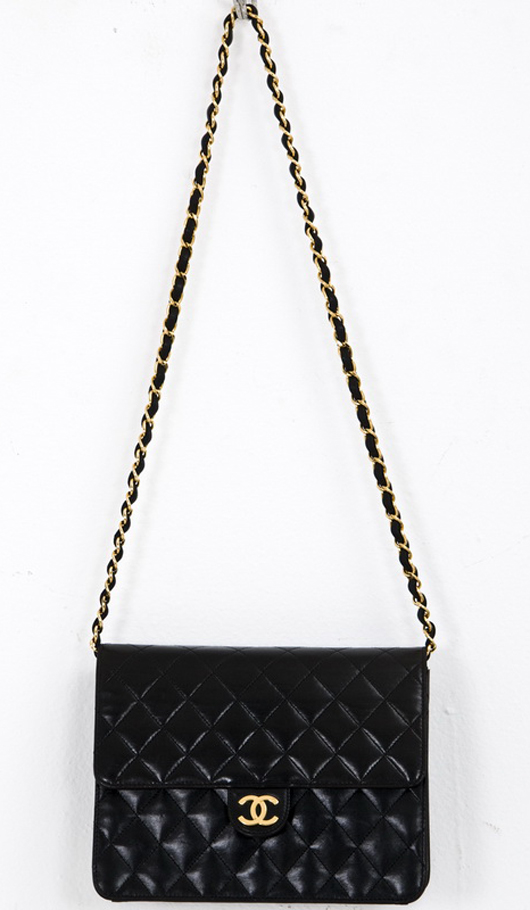 Chanel black small quilted handbag. Flap-over bag with single long chain, burgundy lining, single zipper pocket, 7 inches high, 9 inches wide. Abell Auction Co. image.