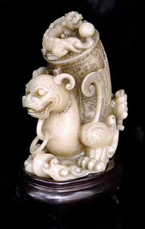 Fine Ming Dynasty shoushan stone carving of a qilin with rhyton vessel on its back. The mythical beast has bulging eyes under bushy brows and short antlers with suspended loose rings under the chin. Gianguan Auctions image.