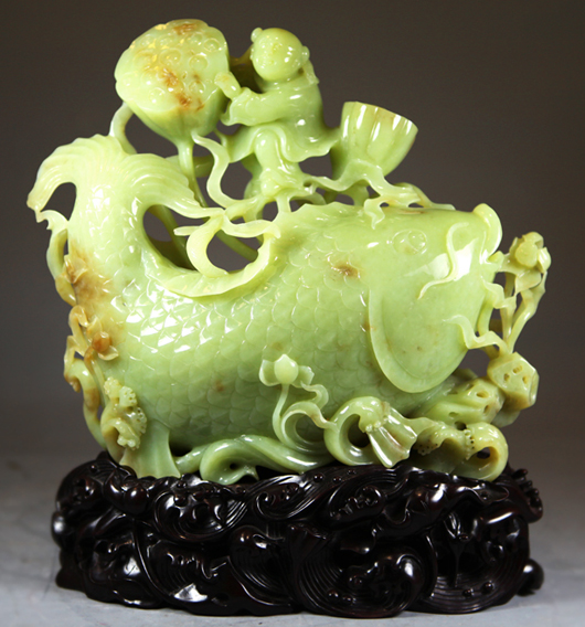 Exquisitely carved jadeite, child playing with lotus. China Arts image.