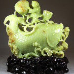 Exquisitely carved jadeite, child playing with lotus. China Arts image.