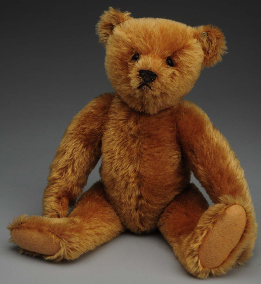 Early Steiff mohair teddy bear, honey color, 12 inches, $4,800. Morphy Auctions image.