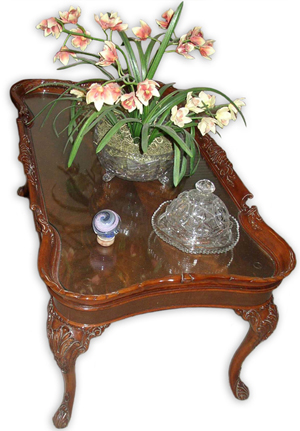 A piece of custom cut glass has protected the crotch mahogany top of this Depression-era coffee table from dustables, kids, pets and general wear for 30 years.