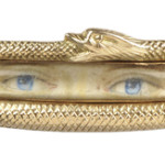 A portrait of a pair of blue eyes and eyebrows is in the center of this antique 'lover's eye' brooch. A gold snake is curled around the edge of the frame. The brooch sold for $2,280 at a Skinner auction in Boston.