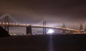 The standard lighted bridge under fog as seen from Treasure Island. Image by Nitesh Aggerwal. This file is licensed under the Creative Commons Attribution-Share Alike 3.0 Unported license.