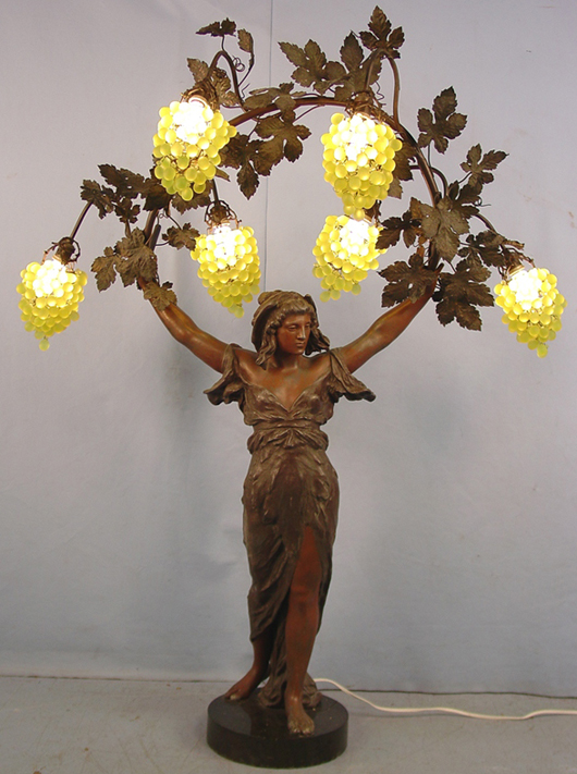 Circa 1920 metal Art Nouveau landing light of a lady with grapes, marble base. Price realized: $10,925. Stevens Auction Co. image.
