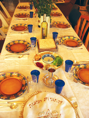 Festive seder table with wine, matza and seder plate. Image by Gilabrand at en.wikipedia. This file is licensed under the Creative Commons Attribution-Share Alike 3.0 Unported license.
