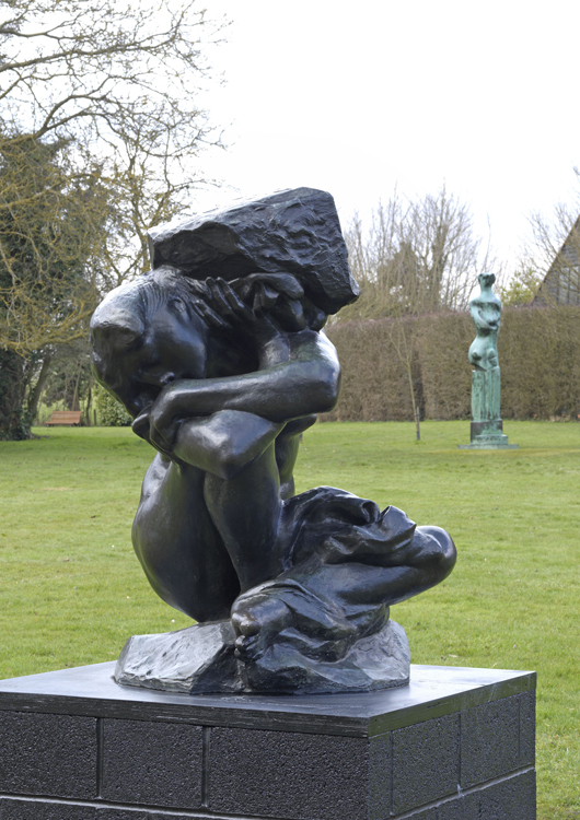 Auguste Rodin, ‘The Fallen Caryatid with Stone,’ 1911-18, with Moore's ‘Upright Motive No.9,’ 1979, in the background. Photo: Mike Bruce. By permission of the Henry Moore Foundation / Musée Rodin, Paris.