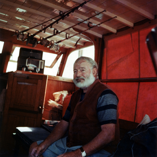 Ernest Hemingway in the cabin of his boat Pilar, off the coast of Cuba, circa 1950. Ernest Hemingway Photograph collection, John F. Kennedy Presidential Library and Museum, Boston.