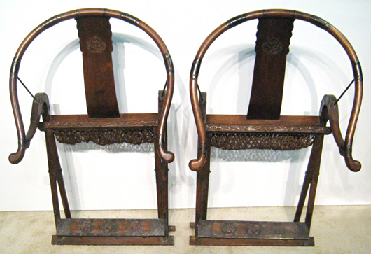 Late 19th century Qing Dynasty Chinese horseshoe-back folding chairs with intricately carved back and arm rests. Gordon S. Converse & Co. image.
