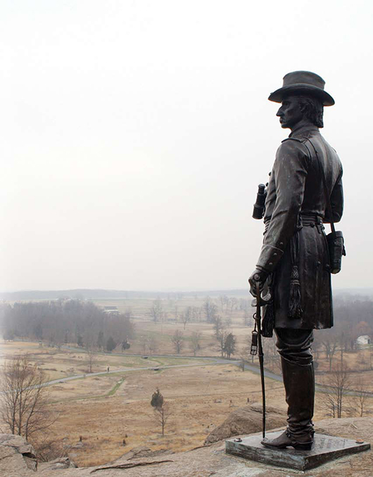 A statue of Union Brig. Gen. Gouverneur K. Warren stands surveying the terrain around Little Round Top at Gettysburg National Military Park. Image by Rob Cox, courtesy of Wikimedia Commons.