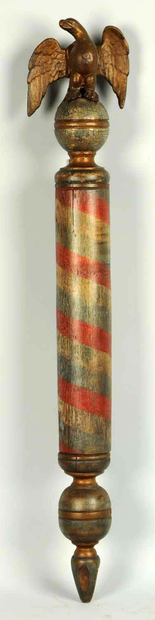 Early 44-inch red and gold striped pole with a three dimensional eagle on finial, $5,700. Morphy Auctions image.