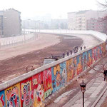 The Berlin Wall has served as a canvas for graffiti art for several decades. This photograph shows the West Berlin side of the wall. The east side of the wall, previously known as the 'death strip,' follows the curve of the Luisenstadt Canal, which was filled in 1932. Photo taken in 1986 by Thierry Noir, licensed under the Creative Commons Attribution-Share Alike 3.0 Unported license.