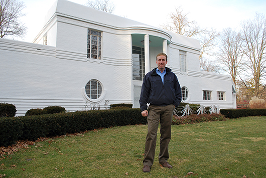 Jeff McCoy stands in front of the T.G. Wilkinson House, which he bought last year and is in the process of restoring. The Art Moderne-style home is constructed of steel-reinforced concrete faced with brick veneer that has been painted white, an element of the original design. Photo Courtesy Indiana Landmarks.