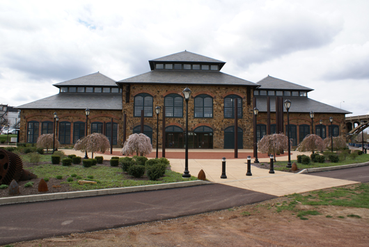 The restored foundry building of the former Phoenix Iron Works. Note the row of Phoenix columns between the lamp posts and building.