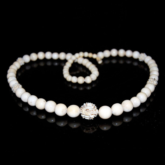 An ivory bead necklace with some pierced beads, 8 7/8 inches long. Gianguan Auctions image.