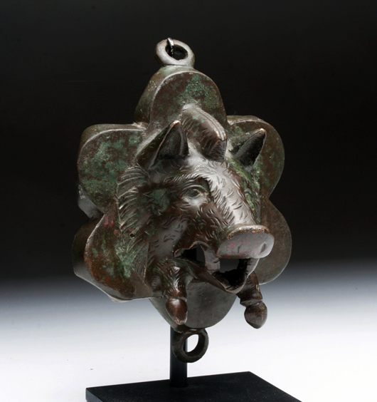 Roman bronze chariot fitting with bas-relief image of a charging boar. Found in a plowed Roman road at Heworth, York, England. Estimate $6,000-$9,000. Antiquities Saleroom image.