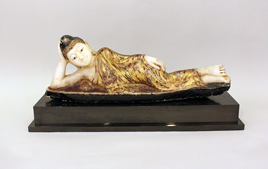 Carved hardstone of a reclining Quan Yin, 9 3/4  inches tall and perched on a rectangular plinth. Ahlers & Ogletree image.