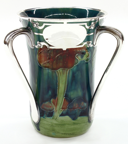 A new world auction record was set for a Moorcroft for Shreve example at Clars. This circa 1905 silver overlaid loving cup in the Claremont pattern soared to $32,130. Clars Auction Gallery image.