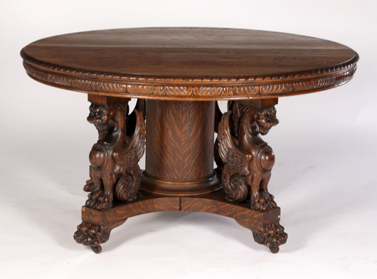 Lot 124 - American Victorian griffin carved oak dining table with seven original leaves, 54 inches diameter, circa 1890. Kamelot Auction House image.