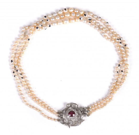 Three-strand natural and cultured pearl necklace composed of strands with 69, 73 and 69 pearls, attached to a scrolled foliate diamond clasp centered with an oval cut ruby and diamond flower head cluster. Estimate: £5,000–£7,000. Dreweatts & Bloomsbury image.