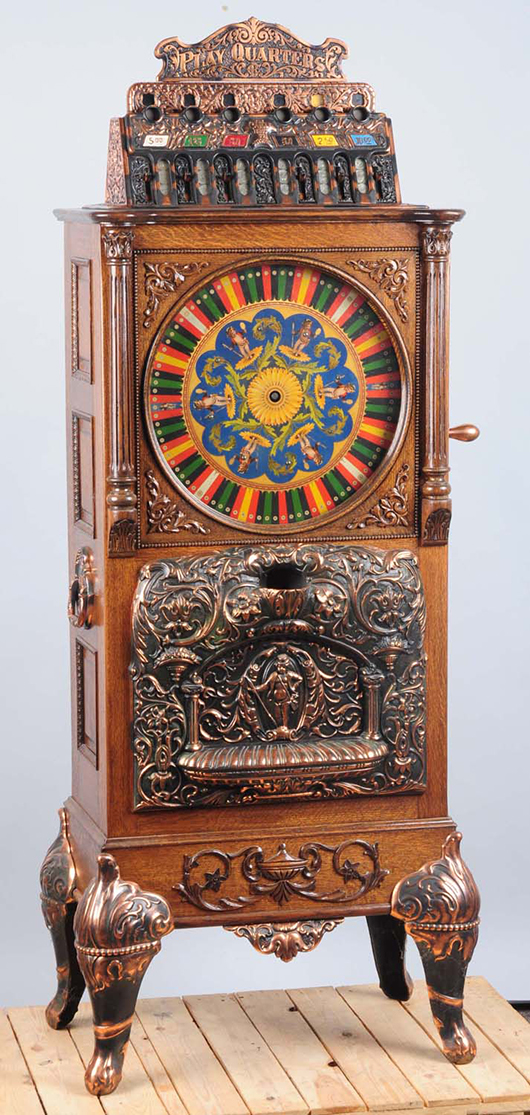 Caille upright slot machine, 69in tall, oak case with antique copper finish, est. $16,000-$24,000. Morphy Auctions image.