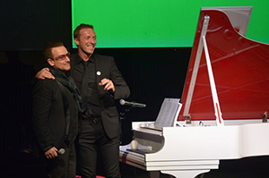 Bono (L) and Chris Martin perform onstage during Jony And Marc's (RED) Auction at Sotheby's on November 23, 2013 in New York City. The piano was subsequently auctioned for $1.9 million. Photo by Mike Coppola/Getty Images for (RED).