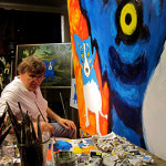 George Rodrigue at work on a large canvas featuring his signature 'Blue Dog.' Image courtesy of The George Rodrigue Foundation Inc.