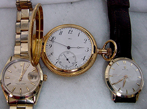 Two men’s gold Rolex wristwatches (left and right) and an 18K gold Tiffany pocket watch. John W. Coker Auctions image.