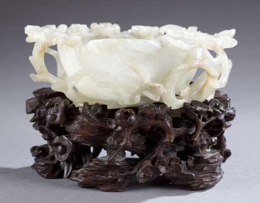 Chinese Late Qing Dynasty jadeite flower-form water coupe on carved-wood stand. Estimate $6,000-$8,000. Quinn’s Auction Galleries image.