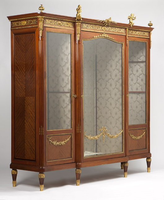 Gilt bronze cherubs perch atop this walnut and parquetry vitrine by the important Paris maker Paul Sormani, offered for $15,000-$20,000. John Moran Auctioneers image.