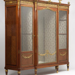 Gilt bronze cherubs perch atop this walnut and parquetry vitrine by the important Paris maker Paul Sormani, offered for $15,000-$20,000. John Moran Auctioneers image.
