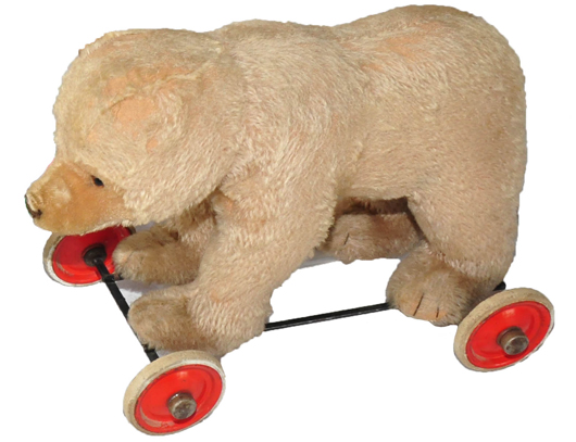 Early Steiff mohair bear on original wheeled platform.